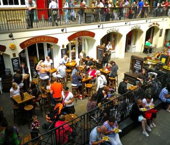 terraza con muchas mesas y personas en ellas comiendo