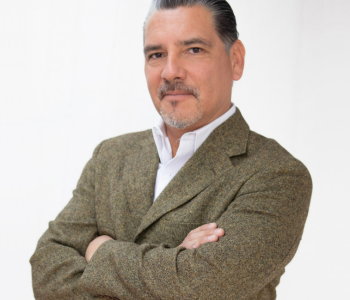 foto de Juan Medina. Hombre vestido de traje, moreno de piel pelo oscuro con canas, bigote y perilla