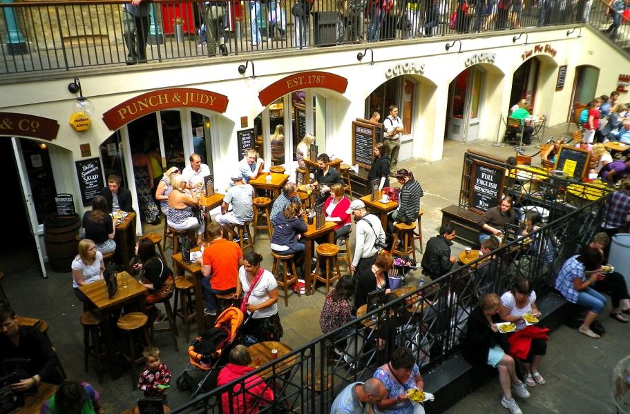 terraza con muchas mesas y personas en ellas comiendo