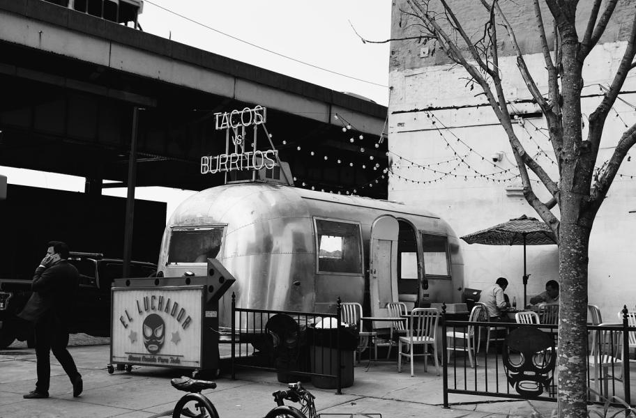 Foto Foodtruck foto en blanco y negro de foodtruck metalizado con cartel de "El luchador" y otro que dice tacos y burritos