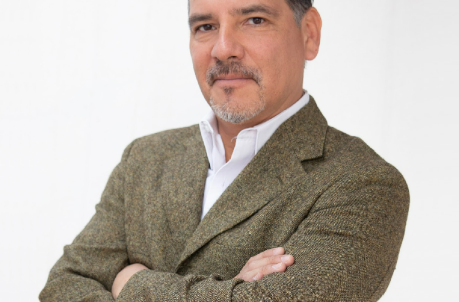 foto de Juan Medina. Hombre vestido de traje, moreno de piel pelo oscuro con canas, bigote y perilla